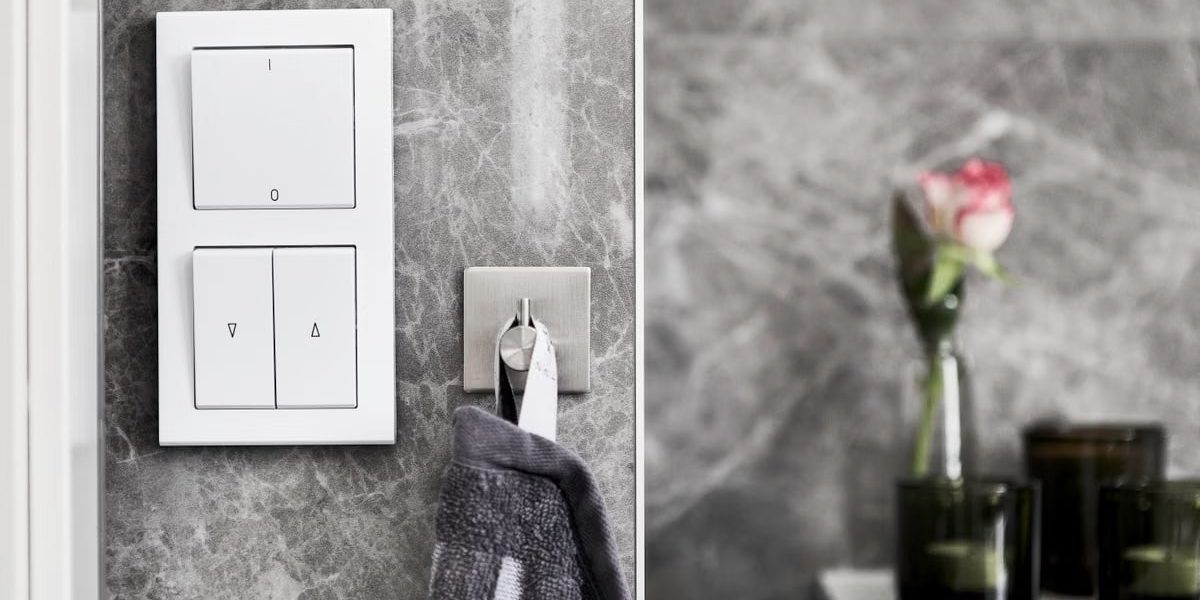 Elegant bathroom featuring marble wall, switch, and minimalist decor.