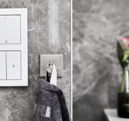 Elegant bathroom featuring marble wall, switch, and minimalist decor.